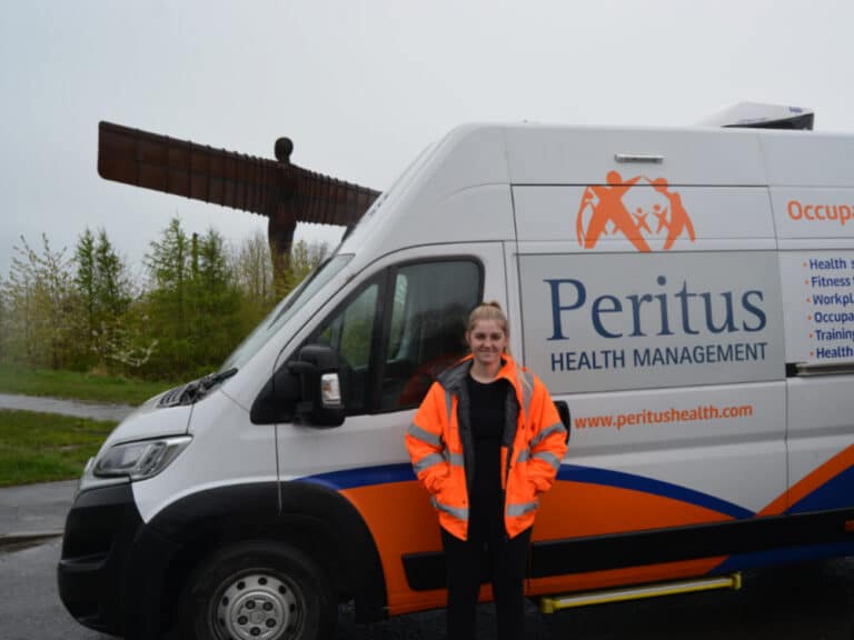 a woman stood by a van in front of the angel of the north